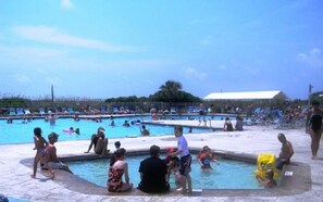 A public swimming pool with multiple lanes and people swimming and relaxing around it. - 2-Bdrm Condo Meets Family Desires - Beachfront Resort - Full Amenities - C13 (Hilton Head Island)