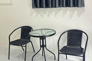 Une pièce avec deux chaises en métal noir et une table ronde.