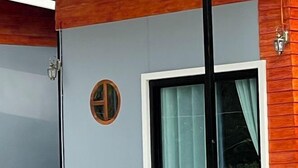 Una habitación con un ventanal grande, un panel de pared de madera y una pequeña ventana circular.