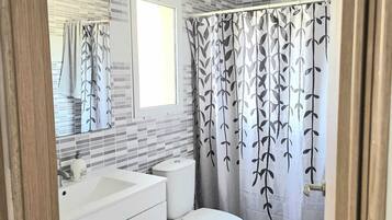 Een haardroger, handdoeken, zeep, toiletpapier