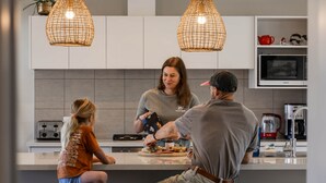 Una cocina moderna con armarios blancos, un microondas y un tostador.