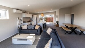 Una sala moderna con sofá, mesa de centro y mesa de comedor.