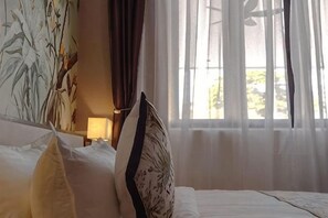 A hotel room with a bed, a nightstand, a lamp, and a window with sheer curtains. - The Palm Suite Tanjung Tokong (Tanjung Tokong)