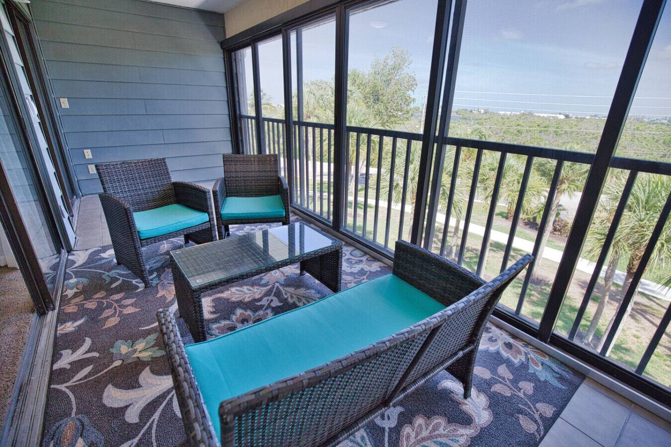 A balcony with wicker furniture and a view of the ocean.