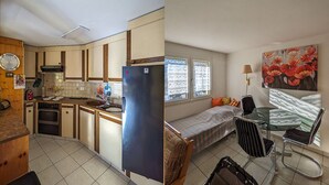 Cocina compacta con refrigerador, estufa y lavamanos, junto a un pequeño comedor con mesa y sillas.