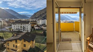 Un edificio residencial con balcón que da a un paisaje montañoso.