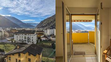 Un immeuble résidentiel doté d’un balcon donnant sur un paysage montagneux.