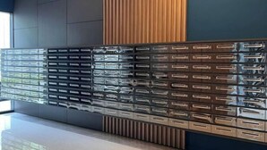 A wall with multiple storage drawers, a wooden panel, and a dark-colored section.