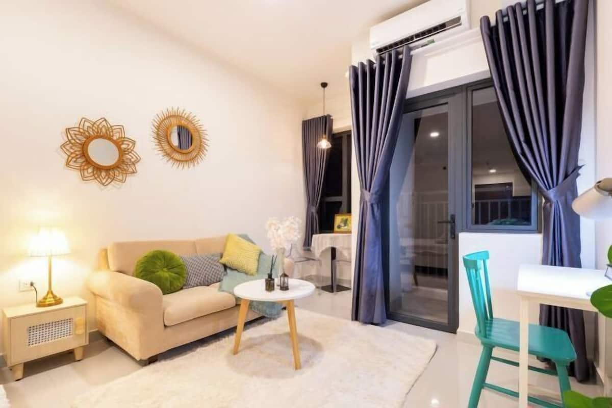 Un salon moderne avec un canapé, une petite table ronde, une lampe et un fauteuil.