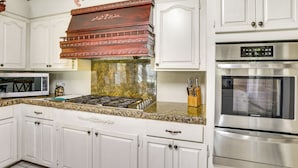 A kitchen with white cabinets, a stainless steel oven, a microwave, and a gas stove. - Fish & Explore: Serene Home on Bayou Petit Caillou (Chauvin)