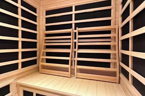 Sauna, jossa on puinen rakenne ja mustat paneelit.