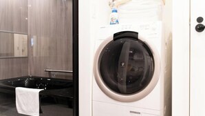 A hotel room with a washing machine, a bathtub, and a towel rack. - Fandina E Resort (Kamakura)