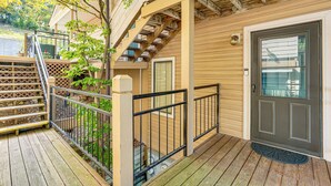 A wooden deck with a metal railing, a door with a glass panel, and a small porch area. - Boat Slip & Pool Access at Lake Ozark Condo! (Lake Ozark)