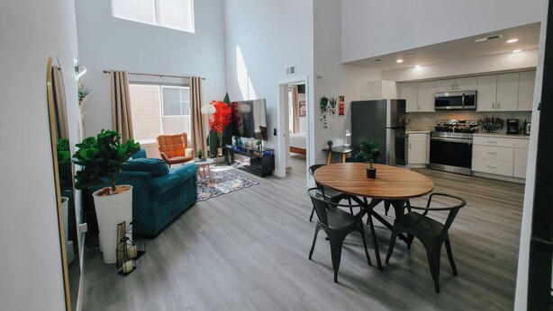 A modern apartment with a living room, dining area, and kitchen.