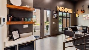 Moderni aula, jossa on vastaanottotiski, «Memphis»-kyltti, piano ja oleskelualue, jossa on sohvia.
