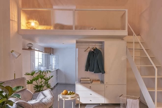 A loft-style bedroom with a bunk bed, a desk, and a hanging chair.