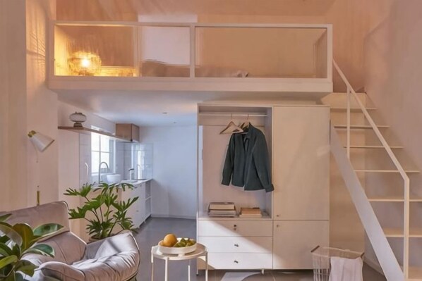Un dormitorio estilo loft con una cama litera, un escritorio y una silla colgante.