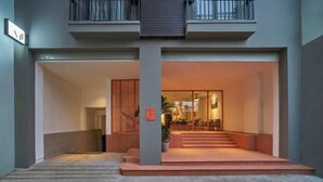 Une entrée moderne, avec un escalier menant à un balcon situé au deuxième étage.