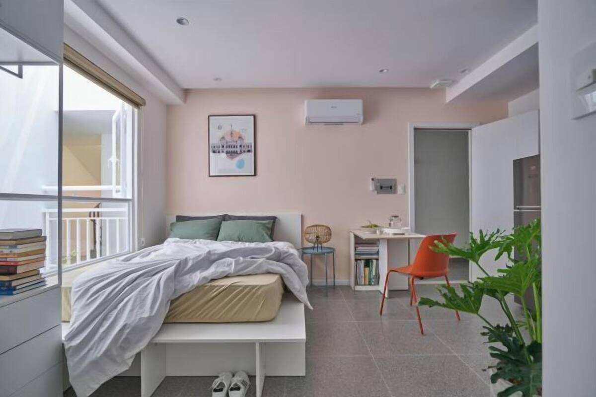 Quarto moderno com cama, mesa de cabeceira e escrivaninha com cadeira.