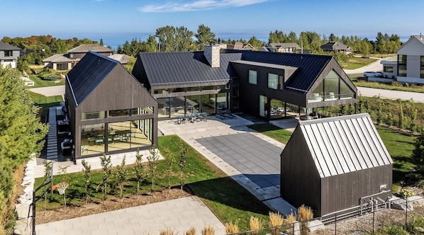 A modern residential building with large glass windows, a spacious patio, and a view of the surrounding neighborhood.