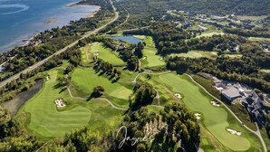 An aerial view of a golf course with multiple holes, a lake, and surrounding residential areas. - Luxurious new 4 bed 5 bath home (The Blue Mountains)