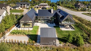 Uma área residencial moderna com casas que possuem amplas janelas e painéis solares.