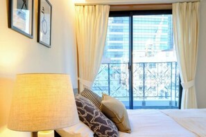 Ein Hotelzimmer mit einem Bett, einer Lampe und einem Fenster mit Vorhängen.