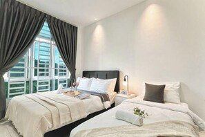 A hotel room with two beds, a large window with curtains, a bedside table with a lamp, and a view of greenery outside. - The Anderson Ipoh Free Netflix & Game Free 2Parking (Ipoh)