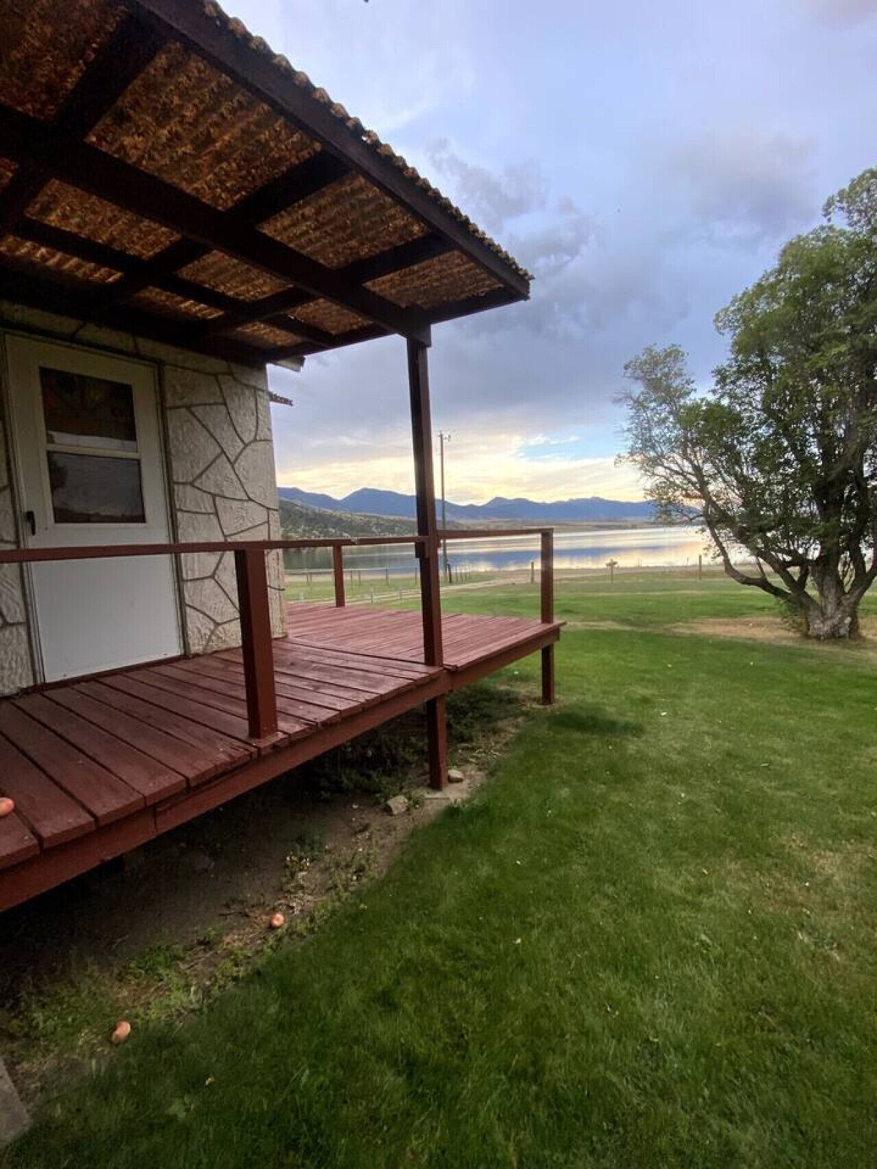A house with a wooden deck and a stone wall.