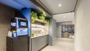 Une cuisine moderne équipée d’une machine à café intégrée, d’un évier et d’un plan de travail agrémenté de plantes.