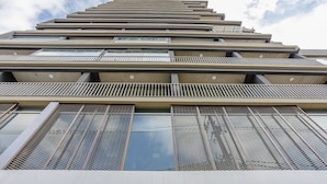 Un immeuble de grande hauteur doté de nombreux balcons et de grandes fenêtres.