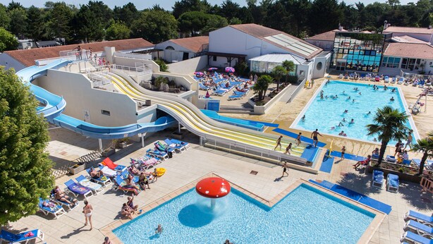 A water park with multiple pools, slides, and sun loungers.