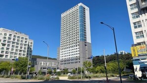 A tall hotel with a grid-like facade, surrounded by other buildings and a clear blue sky. - Skytop INN-TheCity unseo (Incheon)