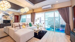 A modern living room with a sofa, a coffee table, and a large window overlooking a pool. - Aurora Life Pool Villa Pattaya (Pattaya)