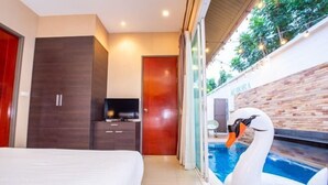 A modern hotel room with a bed, a TV, a wooden wardrobe, a door, and a pool with a swan float. - Aurora Life Pool Villa Pattaya (Pattaya)