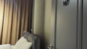 A hotel room with a bed, a nightstand, and a door marked with the number 107.