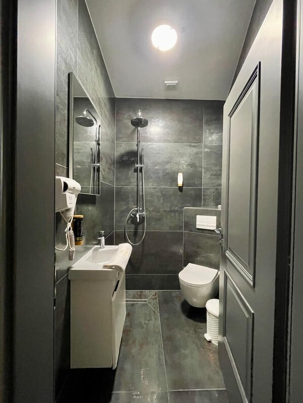 Un baño moderno con ducha, inodoro y lavabo.