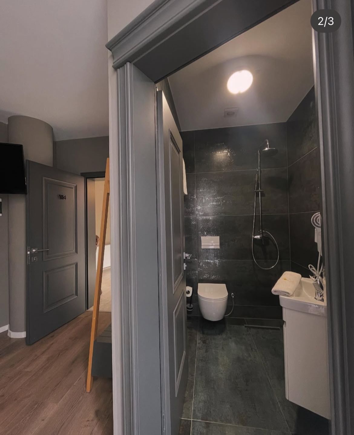 A modern bathroom with a shower, toilet, and sink.
