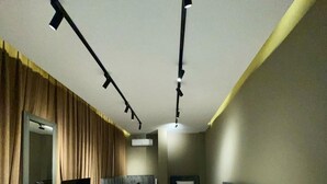 Habitación de hotel moderna con una cama grande, un televisor sobre un mueble bajo y un escritorio con una silla.