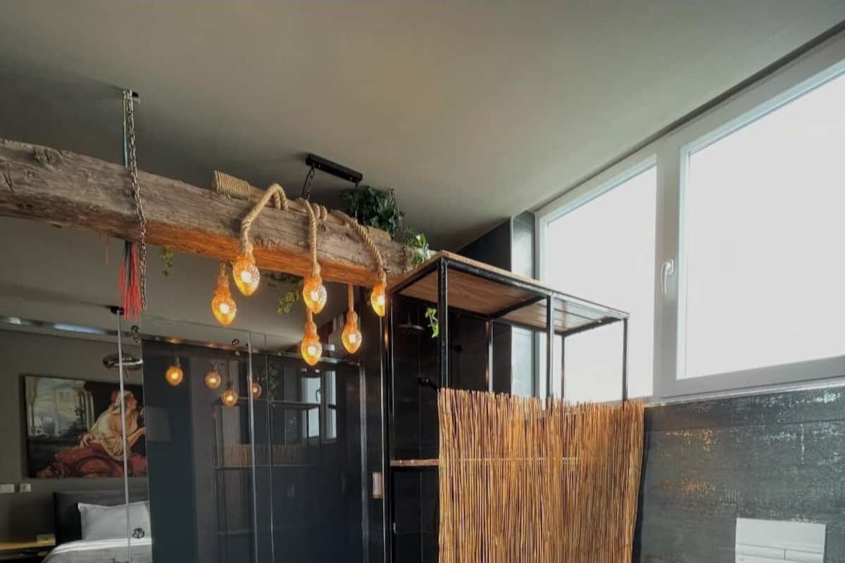 Ein modernes Badezimmer mit Duschkabine aus Glas, einer Holzwand und einer Toilette.