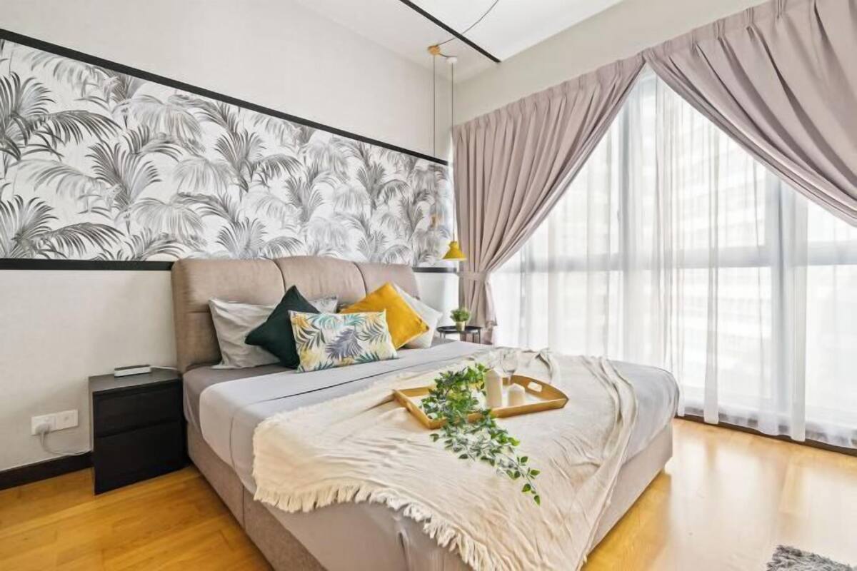 Ein modernes Schlafzimmer mit Bett, Nachttisch und großem Fenster mit Vorhängen.