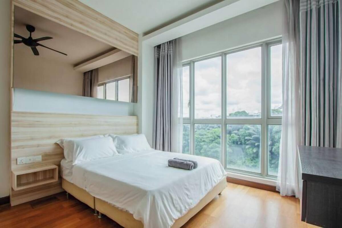 Ein modernes Schlafzimmer mit großem Fenster, einem Bett, einem Nachttisch und einem Deckenventilator.