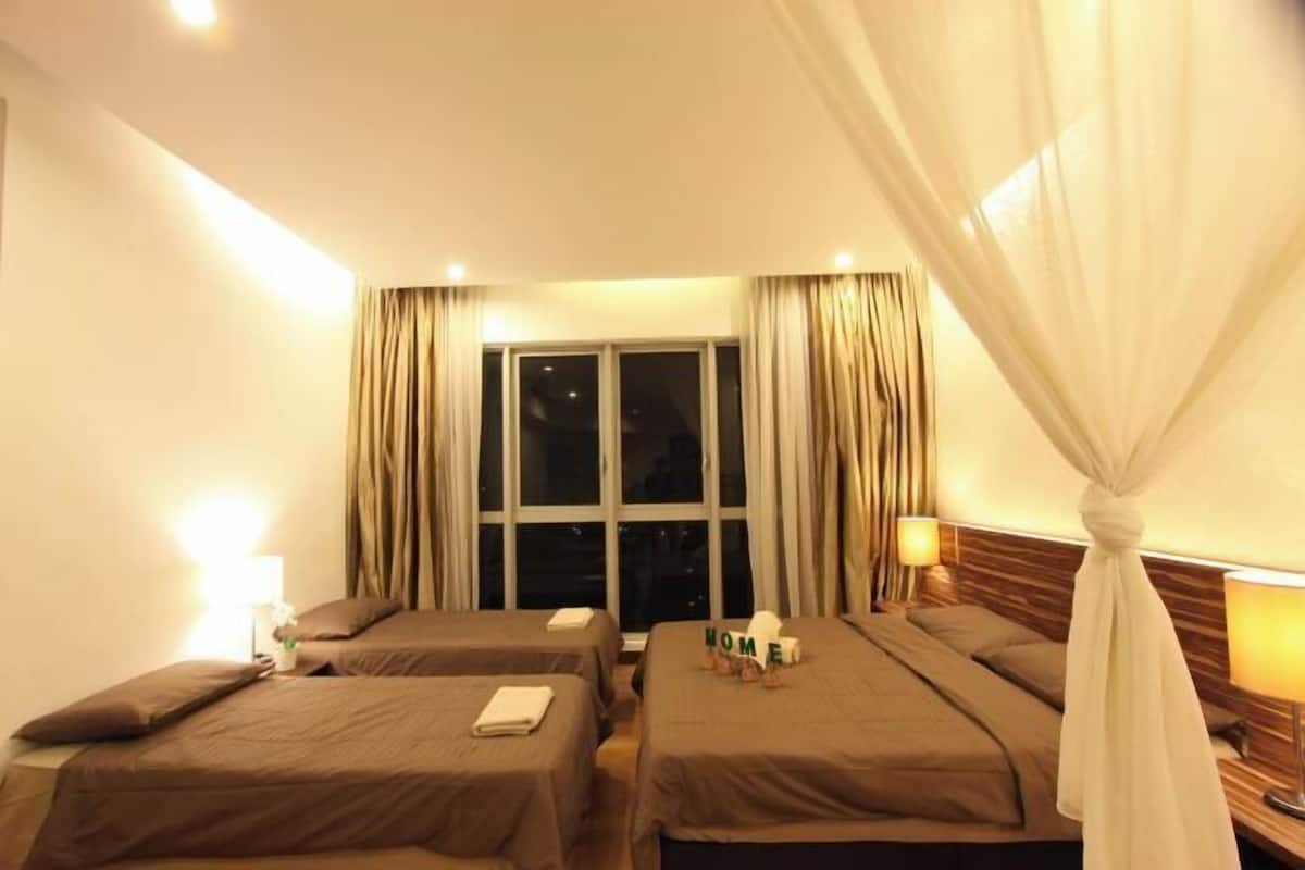 Ein Hotelzimmer mit zwei Betten, einem Fenster, Vorhängen und Nachttischlampen.