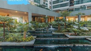 Un hotel con jardín en la azotea, piscina cubierta y varias plantas.