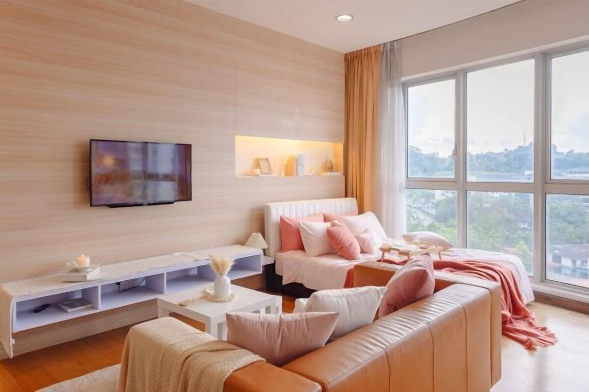 Ein modernes Wohnzimmer mit großem Fenster, Flachbildfernseher, Sofa und Couchtisch.