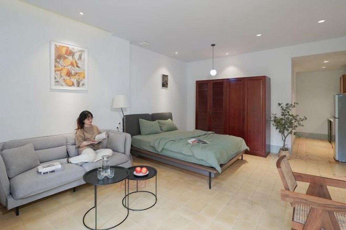 Ein modernes Wohnzimmer mit einer Couch, einem Bett, einem kleinen Tisch mit Getränken und einem Essbereich.
