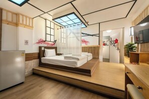 Ein modernes Hotelzimmer mit Bett, Schreibtisch, Fernseher und einem Oberlicht.