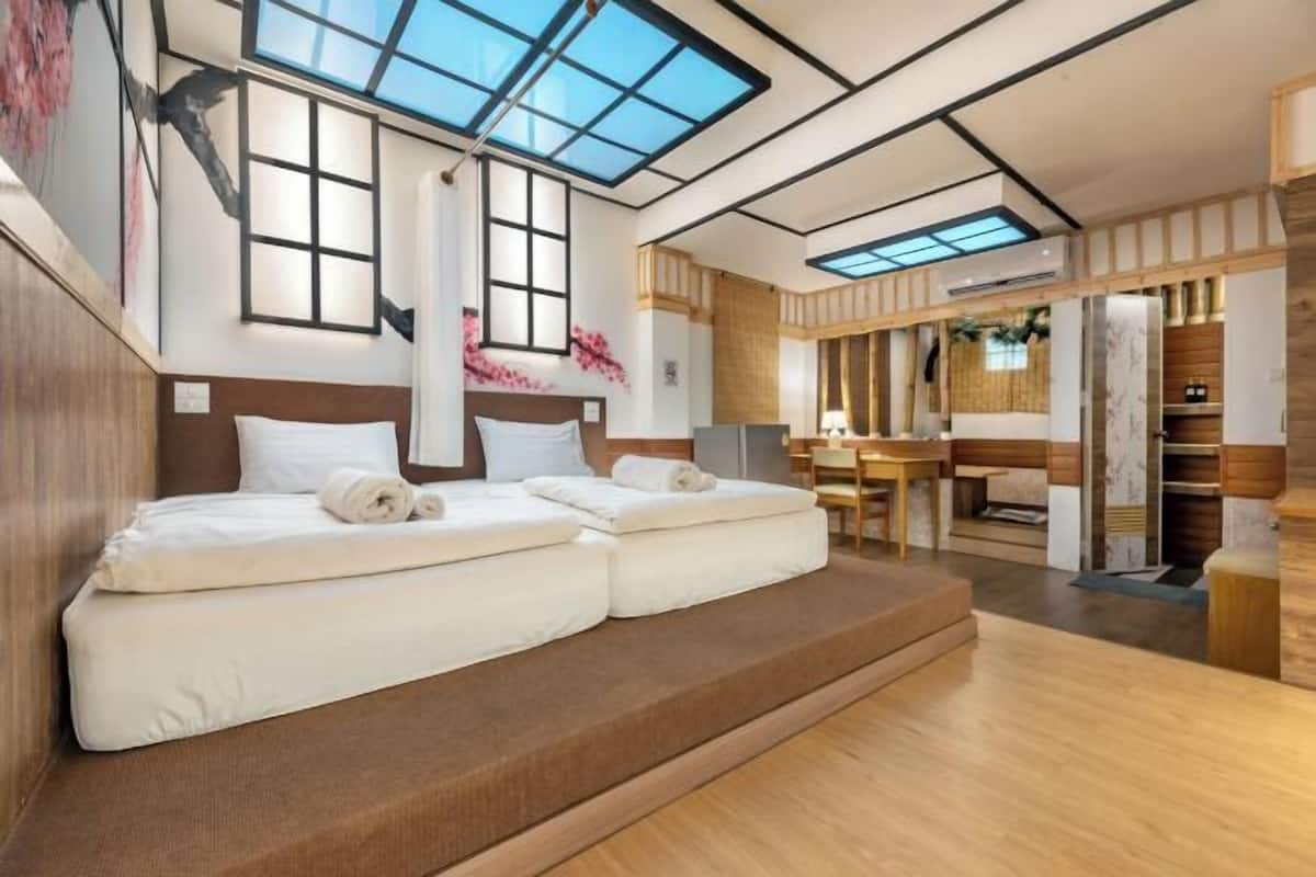 A modern room with a skylight, a bed, a desk, and a wardrobe.