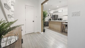 Una cocina moderna con encimera de madera, un taburete de bar y una lámpara colgante.