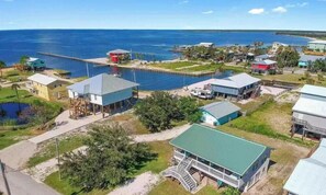 A coastal property with multiple buildings, a dock, and a view of the sea. - Dog Days on the Bay, Fort Morgan (Gulf Shores)